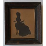 Auguste Edouart (1789-1861) 
A Silhouette of a Seated lady sewing 
Cut paper 
Stamped and dated