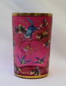A 19th century cranberry glass goblet with a gilt rim and base enamelled with two cats chasing