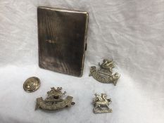 A silver cigarette case with engine turned decoration together with Glamorgan cap badges and a