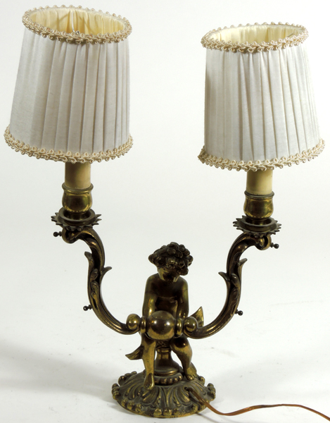 LÁMPARA TPO CANDELABRO de dos luces en bronce dorado con figura de querubín en el centro. Altura: 30
