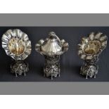 A CONTINENTAL SILVER THREE PIECE GARNITURE the centre piece with removable lid, decorated with