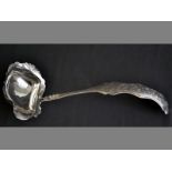 A CONTINENTAL SILVER SOUP LADLE wavy rim, curved handle, engraved with leaves, scrolls and swags, 32