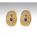 A Pair of Sapphire and Ruby Ear Clips 18k yellow gold ear clips of slightly curved oblong shape,