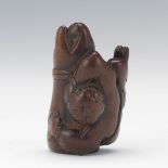 Netsuke of a Boy Resting on a Buddha Hand 2"Carved wooden netsuke of a boy resting on a hand of