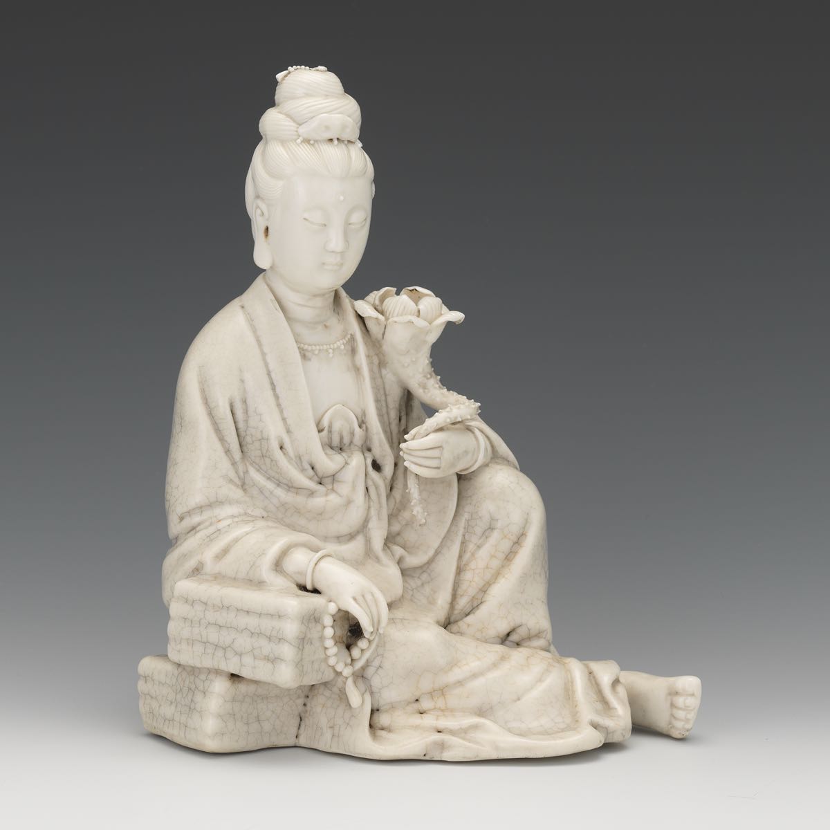 Blanc de Chine Figure of a Female 8-1/4" x 6-3/4" x 6"A white glazed figurine of a seated female