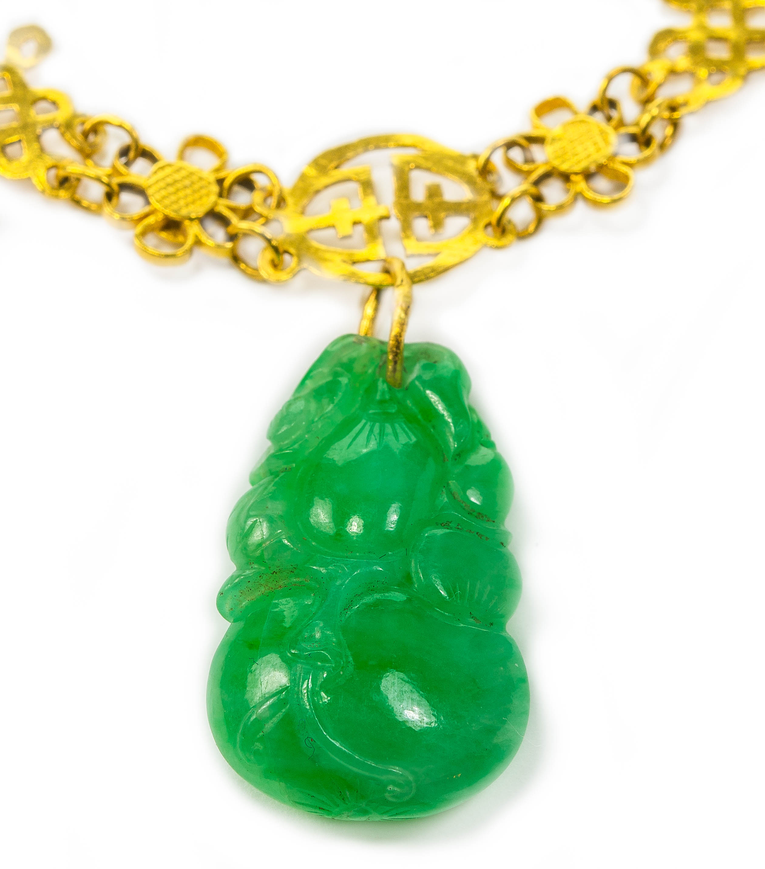 A Chinese gold and jadeite pendant necklace, pendant length 2.5cm width 1.6cm, necklace length 38cm.