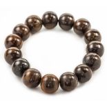 An antique Rhino Horn bead necklace, bead size 15mm, bracelet width 11cm, Wt. 41.5g.