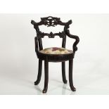 Figural arm chair with carved vine leaves décor, around 1890 Dark stained wood; linen