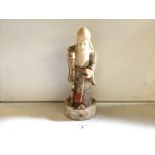 A bone Japanese figure of a bearded man with staff..