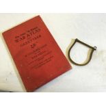 A The Times war atlas and a set of early handcuffs.