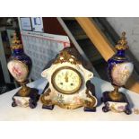 A Petit signed French three piece porcelain clock.