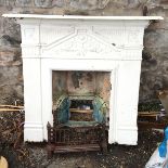 A cast iron fireplace painted white with a mantle.