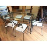 *A wrought iron table with glass top and six wrought iron chairs including two carvers.