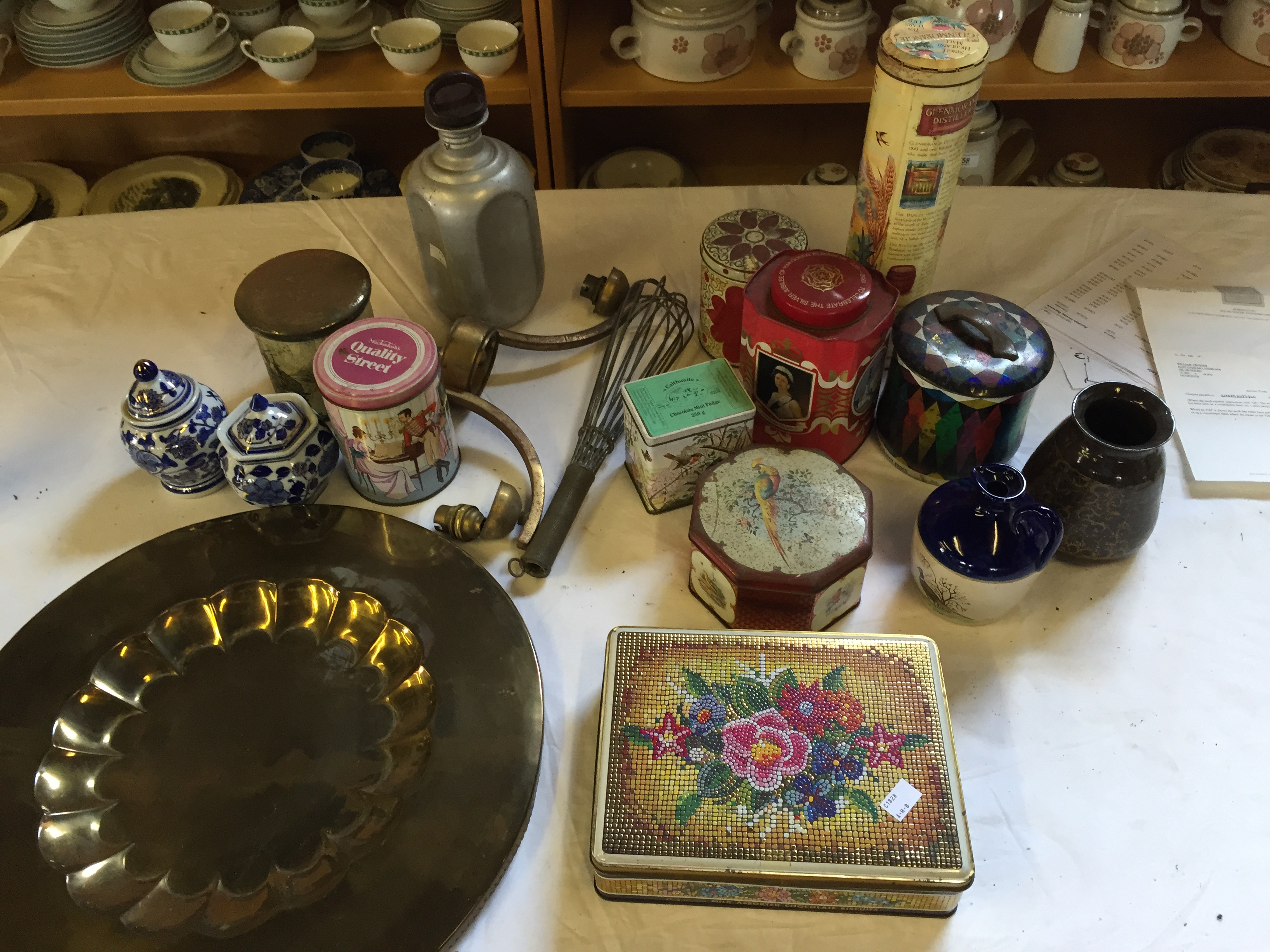 A mixture of items including tins and a brass plate.