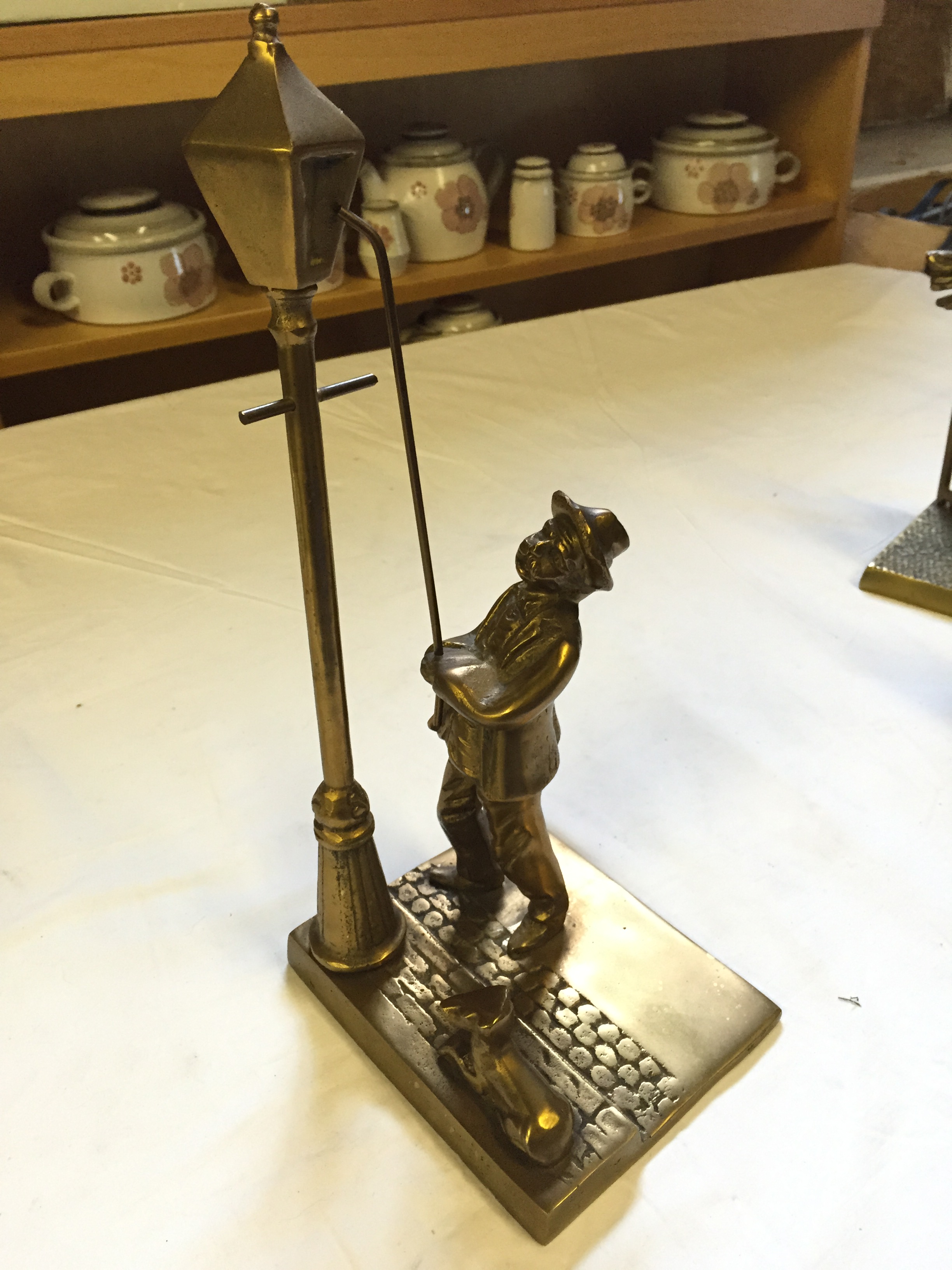 A brass lamplighter figure.