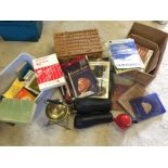 A brass tea pot and warmer a pair of leather gaiters a small wicker hamper basket and books.