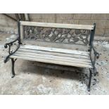 A garden bench wit cast iron ends and back insert.