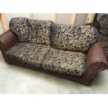 *A three seater cane sofa.