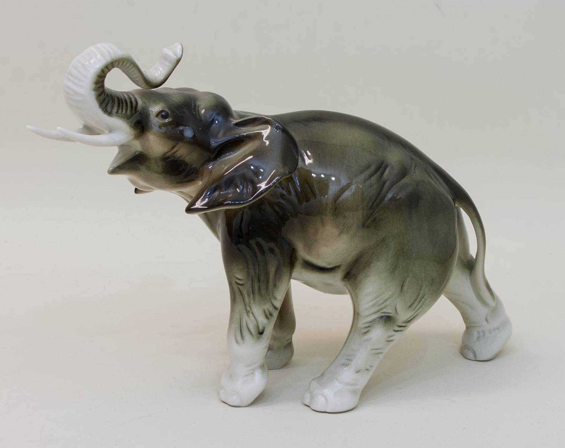 ElefantPorzellanmanufaktur Royal Dux/ Böhmen, Elefant mit erhobenem Rüssel, H. 20 cmMindestpreis: 40