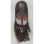 Maskeder Massai, Holz, geschnitzt und partiell farbig gefasst, mit 3 echten Tier-Zähnen und Jute-