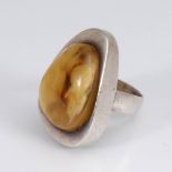 Reserve: 60 EUR        Damenring mit Bernstein. 925 Silber. Wolkiggelber ovaler Cabochon in breitem,