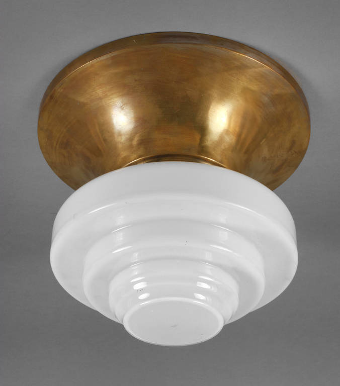 Deckenlampe Art déco
um 1930, Montierung aus vergoldetem Messingblech, getreppter Milchglasschirm,