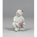 SCULPTURE IN POLYCHROME PORCELAIN , CHINA 19th CENTURY depicting a child who sustains a great peach.