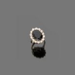 RING in white gold 18 kt., with dark central sapphire and diamond surround. Diamonds ct. 0.70 ca.,