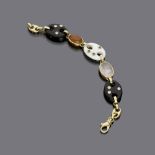 BRACELET

yellow gold 18 kt., elements in carnelian, onyx and pink quartz, with set emeralds and