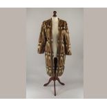 FUR COAT.
A small pelt fur coat. Length 100cm. CONDITION REPORTS: This is a rather odd garment!