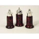 CORNISH SERPENTINE.
A set of three Edwardian, silver mounted, red Cornish serpentine condiments.