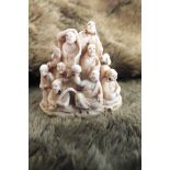 Ivory netsuke of seated and standing Chinese male figures huddled together in a group in pyramid