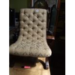 A BUTTONED NURSING CHAIR IN GOLD BROCADE WITH SABER LEGS