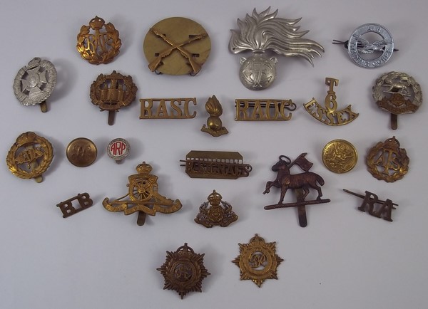 A quantity of military cap badges and bu