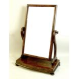 A Victorian mahogany toilet mirror with cushion frame and reeded supports, the base raised on