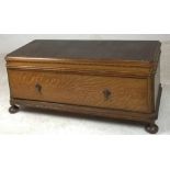 An early 20th century oak blanket chest with canted corners and long single drawer, raised on bun