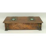 An Arts & Crafts copper box with embossed strap work hinges set with high fired Ruskin type