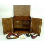 An oak smoker's cabinet, early 20th century, with an interior fitted with drawers and compartments