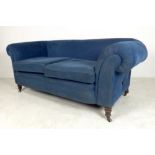 An early Edwardian sofa with turned legs and faux drop end, re-upholstered in blue velour, 182 by