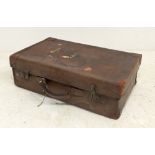 A leather suitcase, circa 1920, initialled F. G. M, with key, 62 by 19 by 38cm.