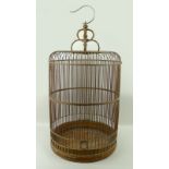 A Chinese bird cage, circa 1930, with bamboo bars, wooden domed top, and metal hanger, 42 by 74cm.