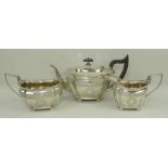 A silver three piece tea set of canted serpentine London shape, engraved with a band of leaves,