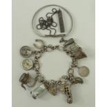 A silver charm bracelet with eleven harms, as fitted, on a heart shaped padlock clasp with safety