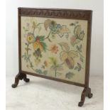 A crewel work and oak framed fire screen, circa 1935, the wool embroidery depicting grapes, vines