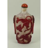 A Chinese red overlay glass snuff bottle, early 19th century, carved with two qilong dragons with