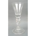 A George II wine glass, circa 1730, the bell shaped bowl with a small tear drop to the base, above