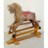 A mid 20th century rocking horse on stand, with fabric covering, and silk stuffed saddle, in pink