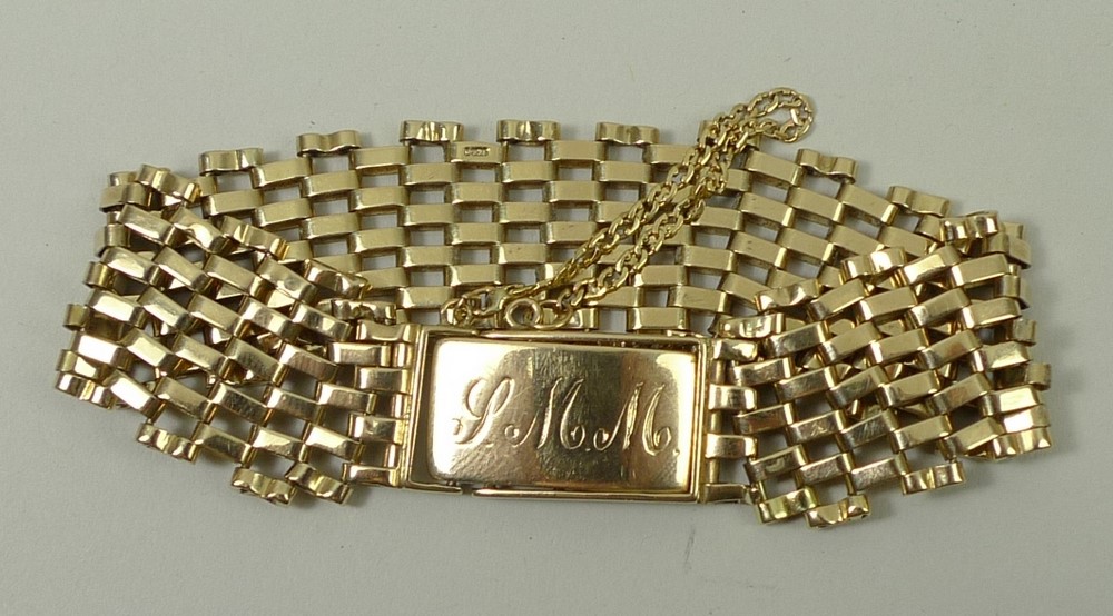 A 9ct gold six bar gate bracelet on an initialled clasp with safety chain, as fitted, 22.4g.