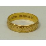 A 22ct gold wedding band with floral engraving, size O, 3.6g.