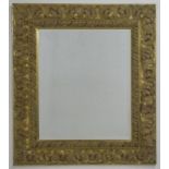 A modern bevelled mirror in a gold composition frame, 77 by 87cm.
